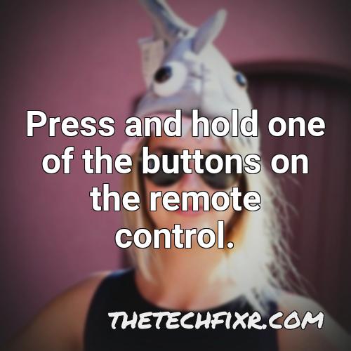 press and hold one of the buttons on the remote control 2